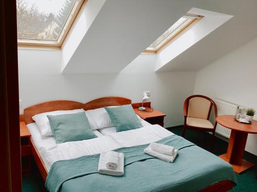 a bedroom with a bed with two towels on it at Golf Hotel Karolina in Karlovy Vary