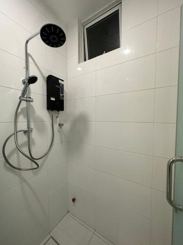 une douche dans une salle de bain carrelée blanche avec une fenêtre dans l'établissement Family Duplex Penthouse 3 Bedroom The Wave Residence 8-9pax, à Malacca