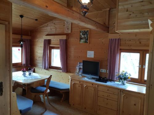 eine Küche mit einem Tisch und einem TV in einer Hütte in der Unterkunft Weiherhütte Ried in Ried im Oberinntal