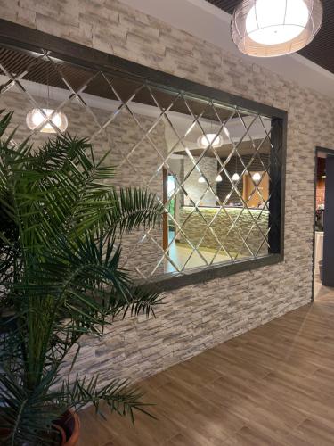 a mirror on a brick wall with a plant at Hotel Rosengarten in Frankfurt/Oder