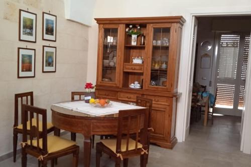 a dining room with a table and a cabinet at Casa Sofia: comodi e tranquilli in Maruggio