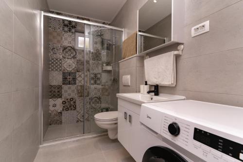 a bathroom with a shower and a toilet and a sink at Sea view apartment Dominique in Cavtat