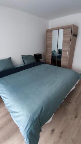 a bedroom with a large bed with a blue comforter at B&B Sabai Sabai Amsterdam in Amsterdam