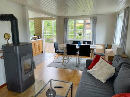 sala de estar con sofá y chimenea en Lovely Waterfront Cottage near Karlshamn en Asarum