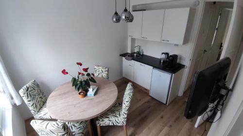 a small kitchen with a wooden table and chairs at B&B Sabai Sabai Amsterdam in Amsterdam