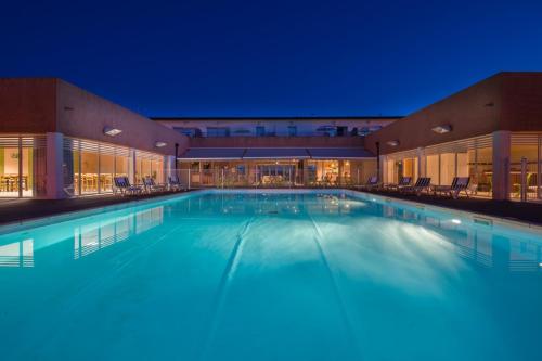 une grande piscine dans un hôtel la nuit dans l'établissement Magnolia, à Rivières