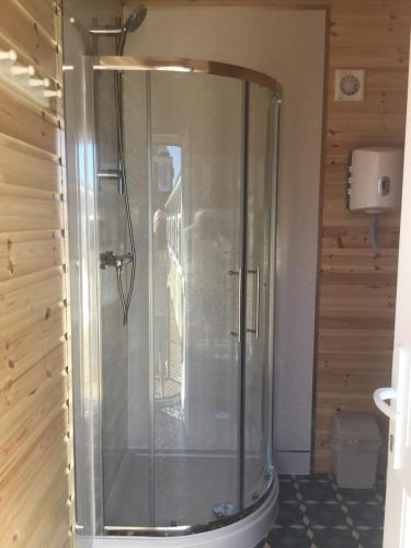 La salle de bains est pourvue d'une douche avec une porte en verre. dans l'établissement Beacon House Bunks, à Bridlington