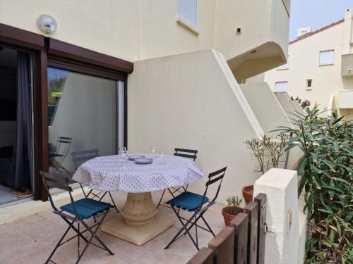 a patio with a table and chairs on a balcony at Studio cabine en bord de plage in Marseillan