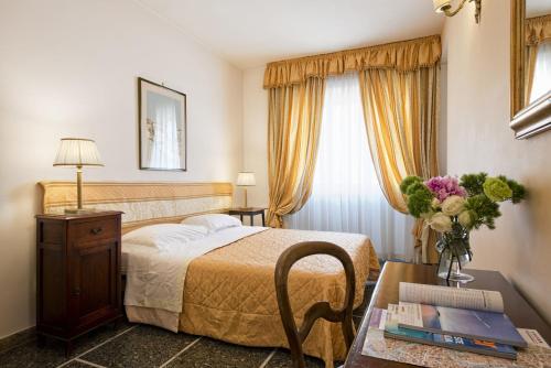 een hotelkamer met een bed en een tafel met een vaas met bloemen bij B&B Le Sibille in Rome