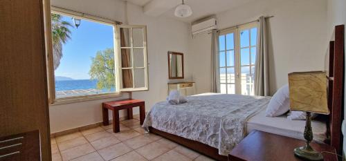 a bedroom with a bed and a view of the ocean at Beachlife: The Apartment in Marmari
