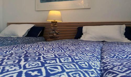 um quarto com 2 camas e um edredão azul e branco em Casa Azmira del Mar em Guatiza