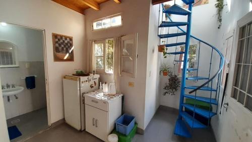 a bathroom with a blue spiral staircase and a refrigerator at Campanita amarilla in Salta