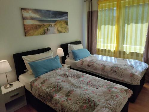 two beds sitting next to each other in a bedroom at Ferienwohnung Rutenberg in Bremerhaven