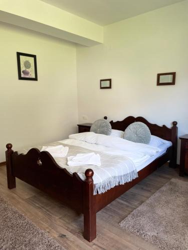 a bedroom with a large bed with white sheets at Valea Salbatica in Şinca Nouă