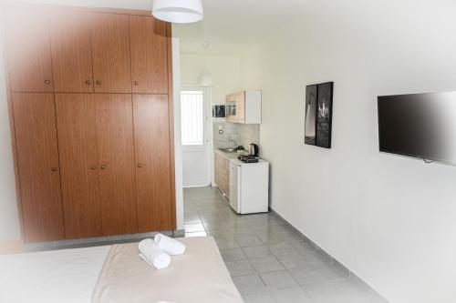 een woonkamer met een televisie en een keuken bij Stacy's Studios in Kremasti