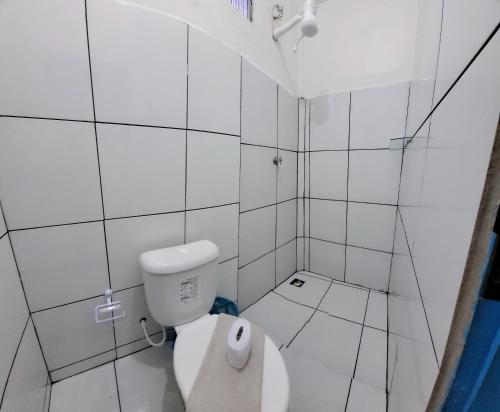 La salle de bains blanche est pourvue d'une douche et de toilettes. dans l'établissement Pousada Luar, à Santa Cruz Cabrália