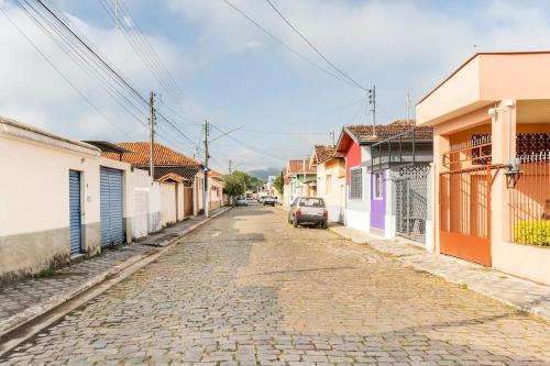 a cobblestone street in a town with a car parked at Pousada Vista da Pedra in São Bento do Sapucaí