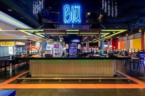 a bar in a casino with a neon sign above it at Hotel Casino Talca in Talca