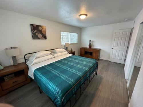 a bedroom with a bed with a green comforter at Central Remodeled Midtown Apt in Sacramento