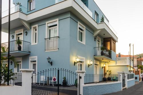 a blue building with a fence in front of it at Blue House in Ponta do Sol