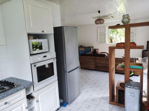 een keuken met een koelkast en een woonkamer bij Villa familiale avec piscine in Le Marin