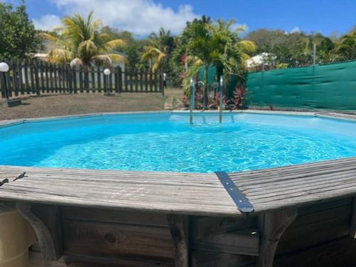 een groot zwembad met een houten terras eromheen bij Villa familiale avec piscine in Le Marin