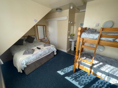 a bedroom with two beds and a bunk bed at Ivydene Guest House in Skegness