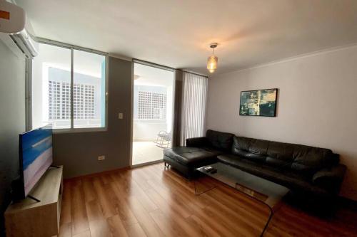 a living room with a leather couch and a television at Apartamento con excelente ubicación! Hasta 4 Personas in Panama City
