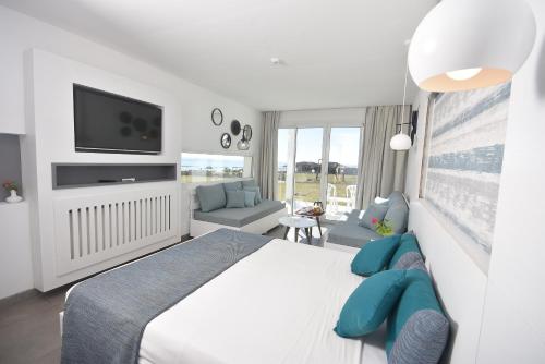 1 dormitorio blanco con 1 cama grande y TV en Amber El Fell en Hammamet Nord