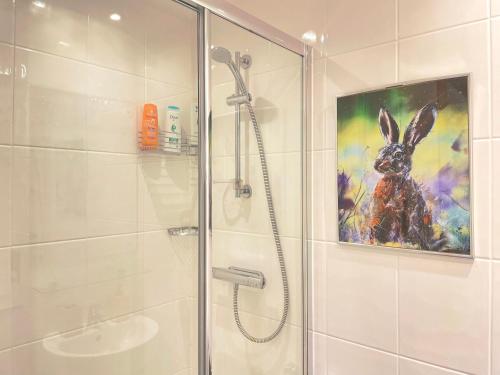 a bathroom with a shower and a painting of a rabbit at Natural Studio by HNFC Stays in Newcastle upon Tyne