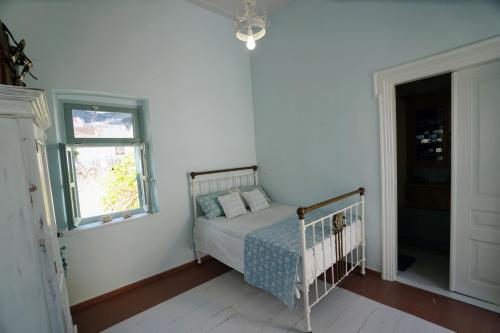 a bedroom with a crib in a room with a window at Say Yes Symi House in Symi