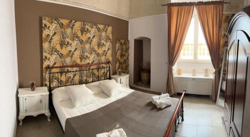 a bedroom with a large bed and a window at B&B LE CUSPIDI in Ginosa