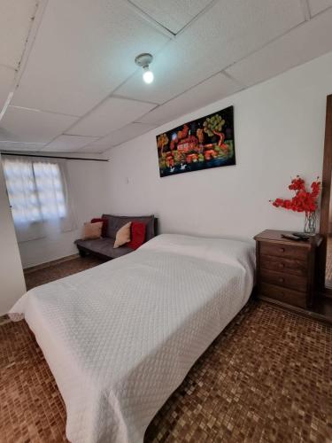 um quarto com uma cama branca e um sofá em apartaestudio charly em Cartagena das Índias