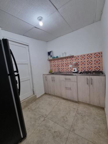 uma cozinha com paredes brancas e uma parede de azulejos laranja em apartaestudio charly em Cartagena das Índias