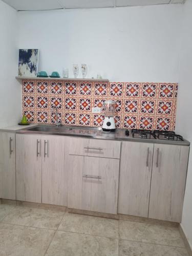 uma cozinha com armários de madeira e uma parede de azulejos em apartaestudio charly em Cartagena das Índias