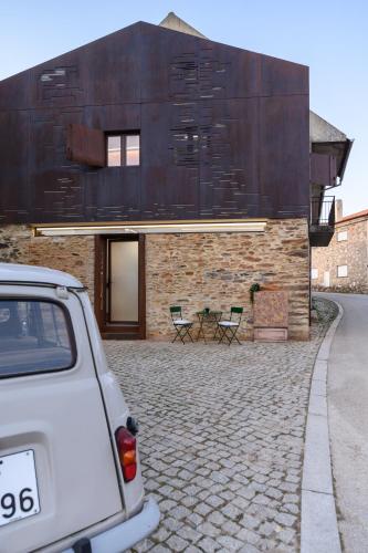a white car parked in front of a building at Casa do Ferreiro in Macedo de Cavaleiros