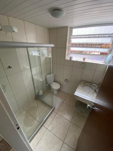 a bathroom with a glass shower and a toilet at Hotel Montanus in Nova Friburgo