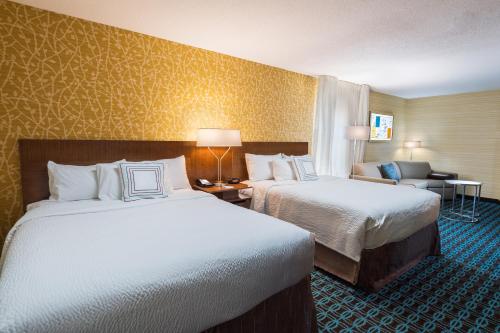 um quarto de hotel com duas camas e uma cadeira em Fairfield by Marriott Inn & Suites Uncasville Mohegan Sun Area em Uncasville