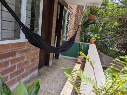 a hammock hanging off the side of a house at Habitación privada en el Poblado. Lo mejor de Medellín muy cerca in Medellín