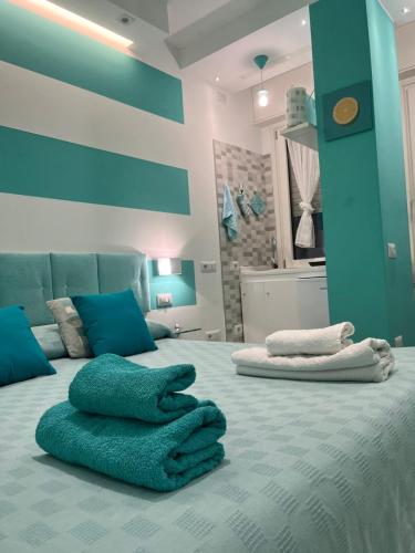 ein Schlafzimmer mit blauen Wänden und ein Bett mit Handtüchern drauf in der Unterkunft IL TURCHESE in Cagliari