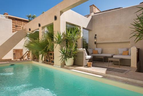 a swimming pool in front of a house at Riad Rossi in Marrakech