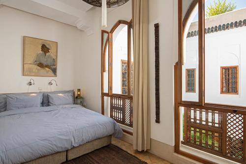 een slaapkamer met een bed en een groot raam bij Riad Rossi in Marrakesh