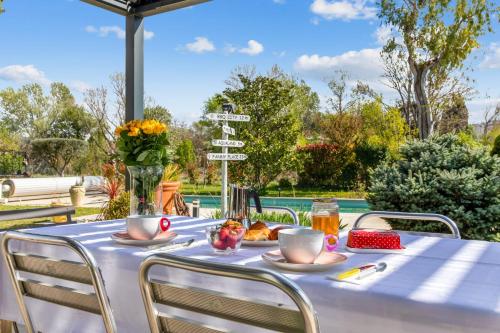 une table avec une nappe bleue, des tasses et des chaises dans l'établissement Villa Massilia - Welkeys, à Aubagne