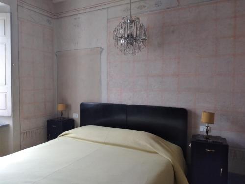 a bedroom with a bed and a chandelier at IL DECUMANO CHARME APARTMENTS in Arezzo