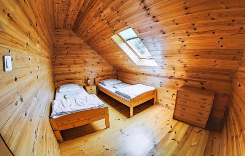 a room with two beds in a wooden cabin at Chłopy Domki u Jacola in Chłopy