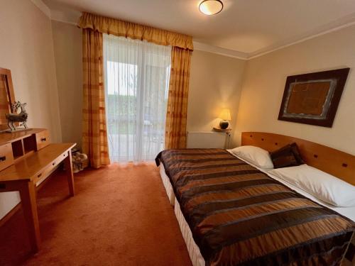 Habitación de hotel con 2 camas y ventana en Luxus Golf Apartment, en Bük