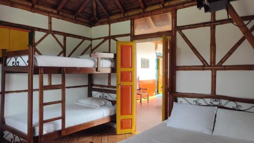 Pokój z 2 łóżkami piętrowymi i drzwiami w obiekcie FINCA HOTEL LA DORADA EJE CAFETERO w mieście Puerto Espejo
