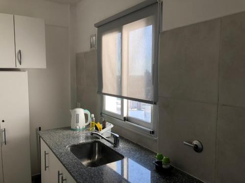 a kitchen with a sink and a window at La Plata Bs As , departamento vista panoramica a metros de todo in La Plata