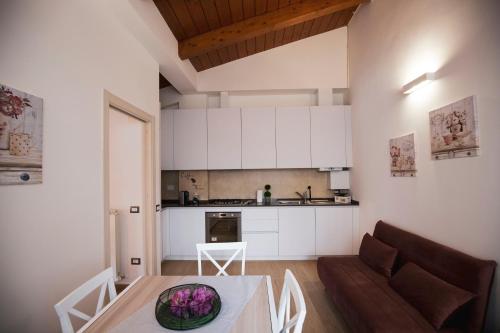 eine Küche und ein Wohnzimmer mit einem Tisch und einem Sofa in der Unterkunft Appartamento Viale Patrono d'Italia in Santa Maria degli Angeli