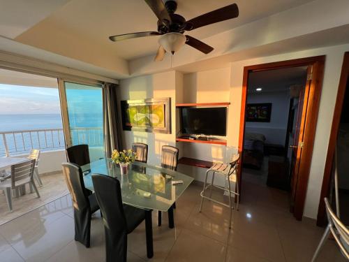 a dining room with a glass table and a television at Ocean View Apartments IH RENTALS in Cartagena de Indias